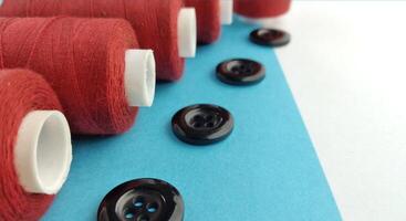 Spools of thread and buttons on a blue and white background. photo
