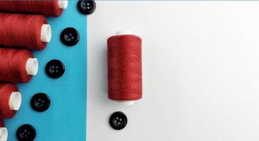 Spools of thread and buttons on a blue and white background. photo