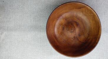 Empty wooden bowl on a linen tablecloth, top view, copy space photo