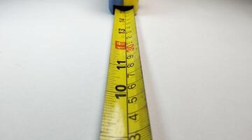 Close up of a tape measure on a white background with copy space photo