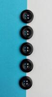 Black buttons on a white and blue background. Selective focus. photo