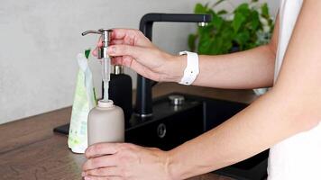 Frau gießt Seife oder Waschmittel von recycelt Verpackung in ein wiederverwendbar Flasche. umweltfreundlich Lebensstil. hoch Qualität 4k Aufnahmen video