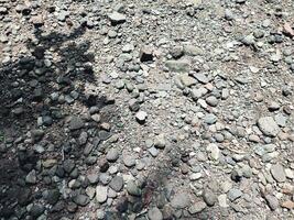 Smooth round pebbles texture background. Pebble sea beach close up, dark wet pebbles and gray dry pebbles photo