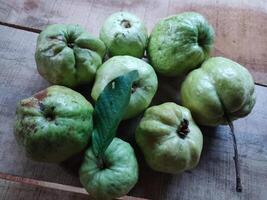 recién escogido cristal guayaba aislado en de madera antecedentes foto