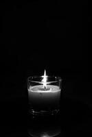 AI generated A monochrome image of a candle burning inside a glass container. Copy Space photo