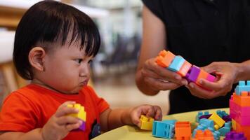 Child boy together with mother playing cubes toys. Toy block. video