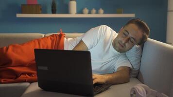 Man using laptop lying down falls asleep. video