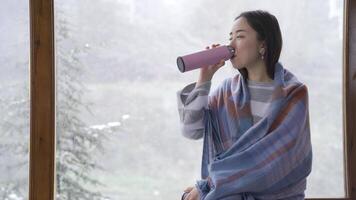 contento asiático joven mujer disfruta invierno por el ventana. video