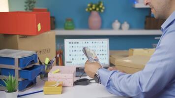 Man selling in his online store is counting money. video