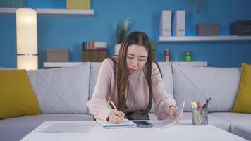 asiático joven mujer haciendo cálculo en su hogar oficina. video