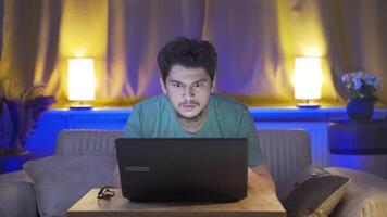 Man focusing on computer has serious expression. At home at night. video