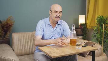 Thoughtful man with wedding ring in hand drinking alcohol. video