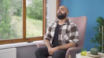 Happy man looks out the window and takes a deep breath. video