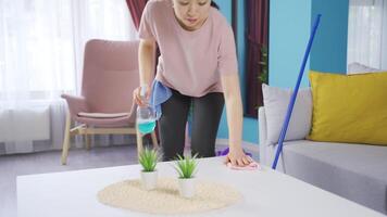 pensativo asiático joven mujer limpieza a hogar. video