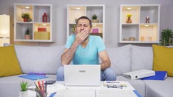 Home office worker man yawns and relaxes at the camera. video