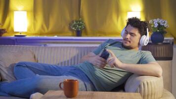 Mann Hören zu Musik- auf Sofa beim Nacht. angenehm und glücklich. video