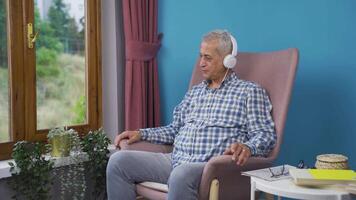 Man looking out the window and listening to music with headphones. video