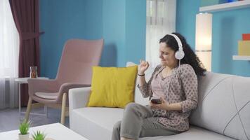 contento joven mujer escuchando a música con auriculares. video