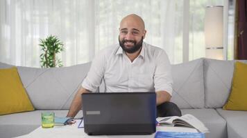 Home office worker man smiles at camera. video