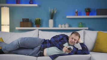 Man lying on the sofa is resting. video