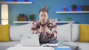 Man working from home enjoys mobile apps on phone. video