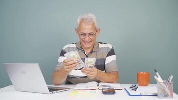 Man looking at laptop counting money. video