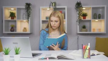 Female student working between paper and laptop. video