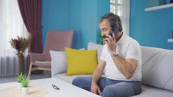 de Mens pratend Aan de telefoon is van streek. hij krijgt slecht nieuws. video