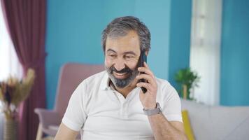 Happy middle-aged man talking on the phone. video