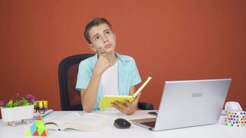 Boy with notebook thinks and takes notes. video