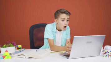 il ragazzo chi piace il applicazione su il il computer portatile è contento. video