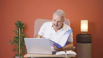 Man working on laptop throws files angrily. video