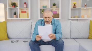 The old man looking at the papers rejoices. video