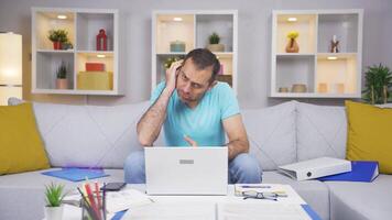 Home office worker man scratches his ears looking at camera. video