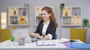 casa escritório trabalhador mulher regozija-se às o que ela vê em a computador portátil. video