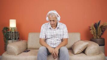 hombre escuchando a música con auriculares es infeliz y triste. video