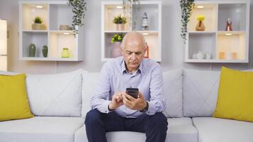 le vieux homme envoyer des SMS sur le téléphone est frustré. video