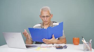 Man working on laptop throws files angrily. video