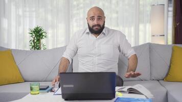 Home office worker man looking at camera with fear and doubt. video