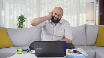 Home office worker man scratches his ears looking at camera. video