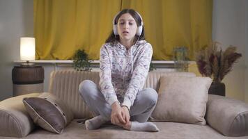 Deprimido joven mujer escuchando a música a hogar a noche. video