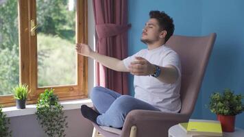 Man doing yoga outside in front of the window. video
