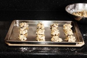 Balls Of Chocolate Chip Cookie Dough On Baking Sheet photo