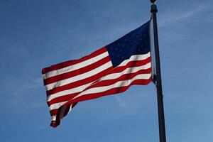 US Flag Backlit on Blue Sky Horizontal photo