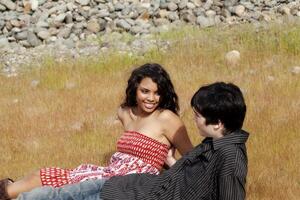 adolescente Pareja sentado en césped al aire libre juntos foto