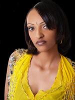 Portrait of young black woman in yellow top with coins photo