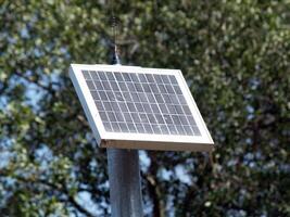 Carmichael, CA, 2009 - small solar panel on pole with trees photo