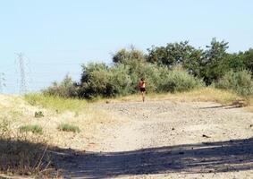 Carmichael, CA, 2009 - Man running down dirt road in black shorts photo