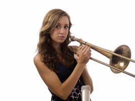 Young teen girl with old trombone and microphone photo