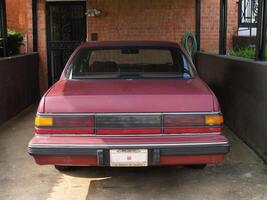 Washington, DC, 2006 - Older Model Automobile Sitting In Car Port Brick House photo